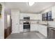Well-lit kitchen with stainless steel appliances, granite countertops, and stylish floating wood shelves at 8198 Wade Hill Ct, Indianapolis, IN 46256