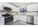 Bright kitchen with white cabinets, stainless steel appliances, subway tile backsplash and granite countertops at 8198 Wade Hill Ct, Indianapolis, IN 46256