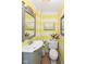 Small bathroom with yellow and white striped walls and a gray vanity at 8365 N Pennsylvania St, Indianapolis, IN 46240