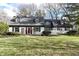 Charming brick ranch home with gray roof, red door, and manicured lawn at 8365 N Pennsylvania St, Indianapolis, IN 46240