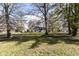 House nestled amongst mature trees in a spacious front yard at 8365 N Pennsylvania St, Indianapolis, IN 46240
