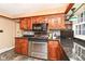 Kitchen with dark wood cabinets, granite countertops, and stainless steel appliances at 8365 N Pennsylvania St, Indianapolis, IN 46240