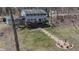 Back of house shows walkout basement with a large wooden deck, a firepit with chairs and treelined backyard at 8850 W State Road 46, Columbus, IN 47201