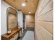 Basement hallway with wood walls, slate floor, and a small table at 8850 W State Road 46, Columbus, IN 47201