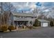 Charming two-story home boasts a well-manicured lawn, attached garage, and welcoming front porch at 8850 W State Road 46, Columbus, IN 47201