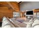 Large living area with a sectional sofa, wood-paneled walls, and wood beams at 8850 W State Road 46, Columbus, IN 47201