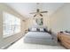 Bright bedroom with a queen bed, fan, and a large window at 10229 Canal Way, Noblesville, IN 46060