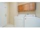 Laundry room features a full size washer and dryer and overhead cabinets at 10229 Canal Way, Noblesville, IN 46060