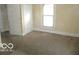 Simple carpeted bedroom with white door and window at 1053 W 35Th St, Indianapolis, IN 46208