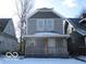 Two-story gray house with a front porch, and snow covered lawn at 1053 W 35Th St, Indianapolis, IN 46208