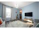 Cozy living room with light blue walls, wood floors, a modern light fixture and large windows at 1130 S Senate Ave, Indianapolis, IN 46225