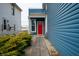Cozy side entrance of a home with a vibrant red door, complemented by lush greenery at 1130 S Senate Ave, Indianapolis, IN 46225