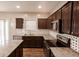 Modern kitchen features dark wood cabinets, stainless steel appliances, and granite countertops at 1284 Jesse Ct, Greenwood, IN 46143