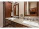 Modern bathroom featuring dual sinks, granite countertops, and dark wood cabinetry at 1468 Alabama St, Indianapolis, IN 46202