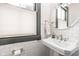 Bathroom featuring subway tile walls, a pedestal sink, and a round mirror above the sink at 1468 Alabama St, Indianapolis, IN 46202