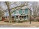 Charming two-story home with teal siding, inviting front porch, and a beautifully landscaped yard at 1468 Alabama St, Indianapolis, IN 46202