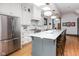 Kitchen with white cabinets, stainless steel refrigerator, and a large gray island with a white countertop at 1468 Alabama St, Indianapolis, IN 46202