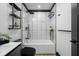 Modern bathroom with white and black tile, bathtub, and shelving at 1730 Union St, Columbus, IN 47201