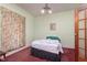 Small bedroom with double bed, floral curtains, and wood door at 2088 E Eden Rd, Greenfield, IN 46140