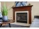 A living room fireplace with a detailed wood mantel and a decorative flower painting above at 3138 River Shore Pl, Indianapolis, IN 46208