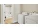 Functional laundry room with washer, dryer, and bathroom access at 3264 Orchard Ave, Indianapolis, IN 46218
