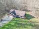 Aerial view of brick home, showing well-kept lawn, gravel driveway, and wooded surroundings at 3510 E Copperstone Rd, Martinsville, IN 46151