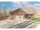 Exterior shot of a brick home, with a gravel driveway and a wooden deck at 3510 E Copperstone Rd, Martinsville, IN 46151