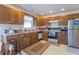 Kitchen featuring wood cabinets, neutral countertops, and stainless-steel refrigerator at 3510 E Copperstone Rd, Martinsville, IN 46151