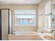 Bathroom with large window overlooking a lake, double vanity, and garden tub at 4348 Princeton Park Dr, Columbus, IN 47201