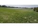 Expansive backyard featuring lush green space and a tranquil pond at 4543 W Meadows Ln, New Palestine, IN 46163