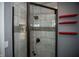 Clean shower with grey tile and red shelves at 460 Park Pl, Martinsville, IN 46151