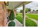 Front porch with brick columns and artificial topiaries at 4657 E 62Nd St, Indianapolis, IN 46220