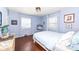 Charming bedroom with hardwood floors, light blue walls, and a full-size bed at 5202 Woodside Dr, Indianapolis, IN 46228