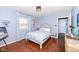 Light blue bedroom with hardwood floors, double bed, and window coverings at 5202 Woodside Dr, Indianapolis, IN 46228