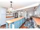 Modern kitchen with a large teal island, stainless steel appliances, and butcher block countertops at 5202 Woodside Dr, Indianapolis, IN 46228