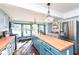 Renovated kitchen with butcher block countertops, stainless steel appliances, and a teal island at 5202 Woodside Dr, Indianapolis, IN 46228