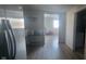 Hallway with light hardwood floors leading into a room with stainless steel refrigerator at 5361 Adelaide St, Indianapolis, IN 46203