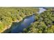 Expansive aerial shot highlighting the property's serene waterfront setting, surrounded by lush greenery and sparkling lake at 6234 Bobwhite Dr, Nineveh, IN 46164