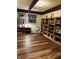 Finished basement with wood-look flooring, open space, and a large bookshelf, perfect for entertainment at 6551 Forrest Commons Blvd, Indianapolis, IN 46277