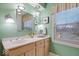 Bathroom with light green walls, light fixture, and window with view of outside at 6551 Forrest Commons Blvd, Indianapolis, IN 46277