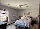 Cozy bedroom with patterned bedspread, bright windows, and a ceiling fan for comfortable living at 6551 Forrest Commons Blvd, Indianapolis, IN 46277