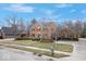 Traditional brick home with green shutters, complemented by mature trees, a manicured lawn, and a driveway at 6551 Forrest Commons Blvd, Indianapolis, IN 46277