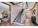 Elegant staircase with patterned carpet, wood trim, and a view into the living room at 6551 Forrest Commons Blvd, Indianapolis, IN 46277