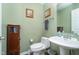 Small powder room with pedestal sink and toilet at 7541 Mather Ln, Indianapolis, IN 46239