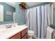 Clean bathroom with striped shower curtain and wood vanity at 7541 Mather Ln, Indianapolis, IN 46239