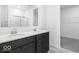 Bathroom showcasing double sinks with dark cabinets and a walk-in shower in the background at 1020 Stonehaven Dr, Indianapolis, IN 46239