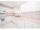 Bright kitchen with white cabinets, pink countertops, and modern appliances at 1217 Charleston Commons Dr # 25, Anderson, IN 46012