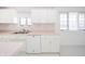 Kitchen with white cabinets, pink countertops, and double sink at 1217 Charleston Commons Dr # 25, Anderson, IN 46012