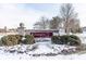 Elegant brick entrance sign for Carmel Pointe Condominiums, enhanced by decorative shrubs and a snowy winter landscape at 12584 Tennyson Ln # 208, Carmel, IN 46032