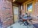 Small patio with brick walls, table, chairs, and potted plants at 131 E Ravenswood Dr # 18-D, Anderson, IN 46012